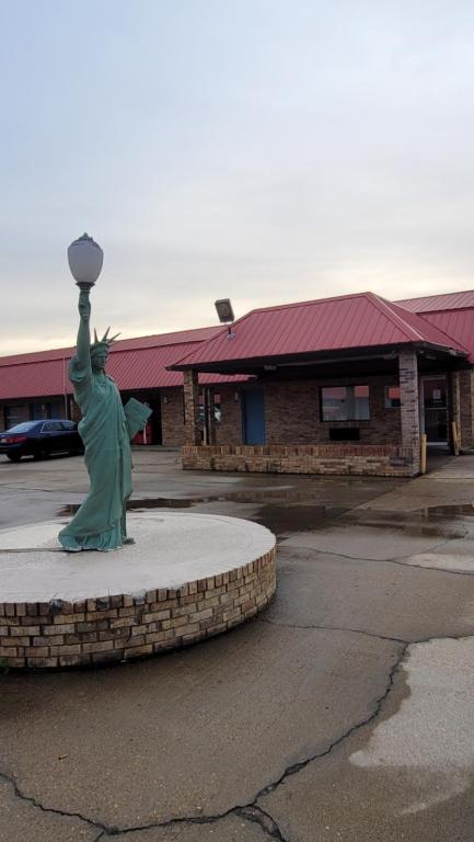 a statue of the statue of liberty in a parking lot at Western Motel in Magee