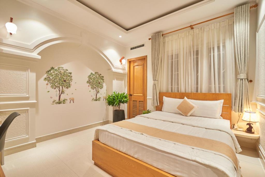a bedroom with a large bed and a window at Bin Bin 10 - Mimosa Hotel Near Tan Son Nhat Airport in Ho Chi Minh City