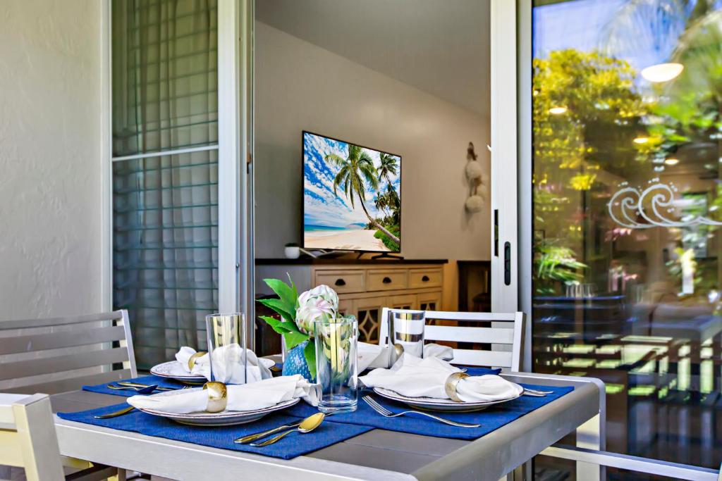 ein blauer Tisch mit Tellern und Servietten darauf in der Unterkunft Napili Puamala 128 in Kahana