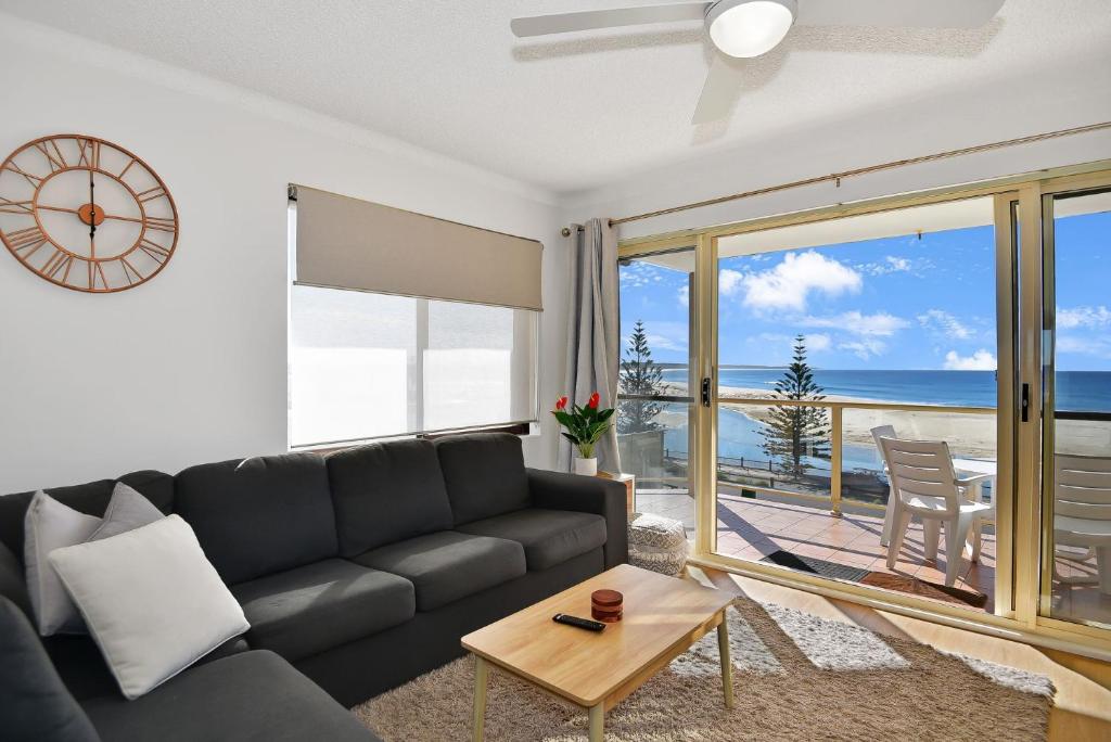 a living room with a couch and a view of the ocean at Avilla Court Stunning Views in The Entrance