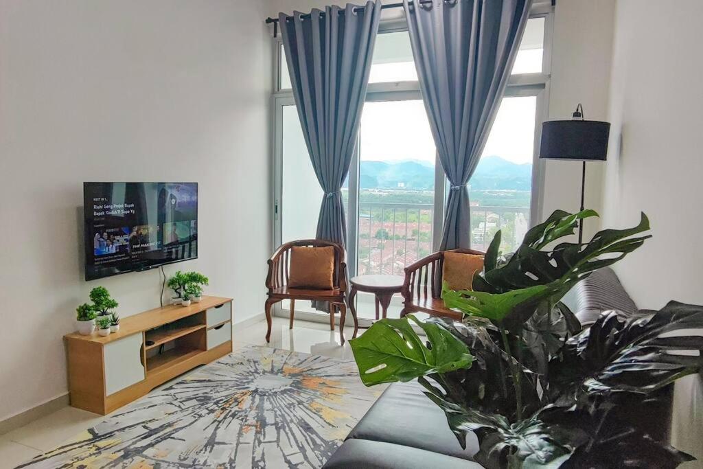 a living room with a large window and a tv at Meru View in Ipoh