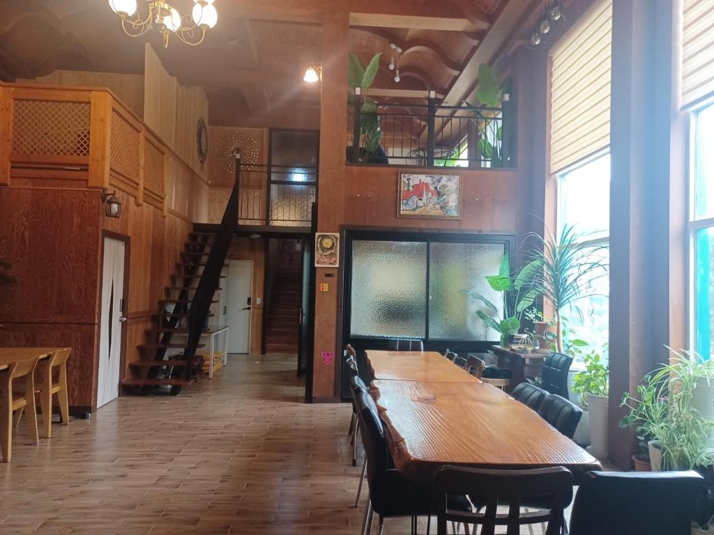 a dining room with a long wooden table and chairs at Vernia in Yeosu