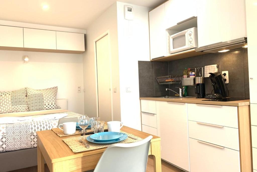 een kleine keuken met een tafel in een klein appartement bij M2 Cosy studio RER BC500m Orly 20 min Netflix in Massy