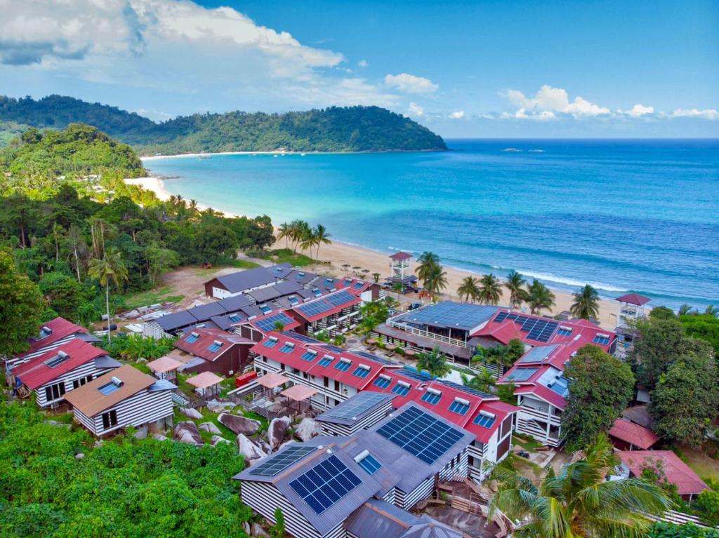 een luchtzicht op een strand met huizen en de oceaan bij The Barat Tioman Beach Resort in Kampong Juara