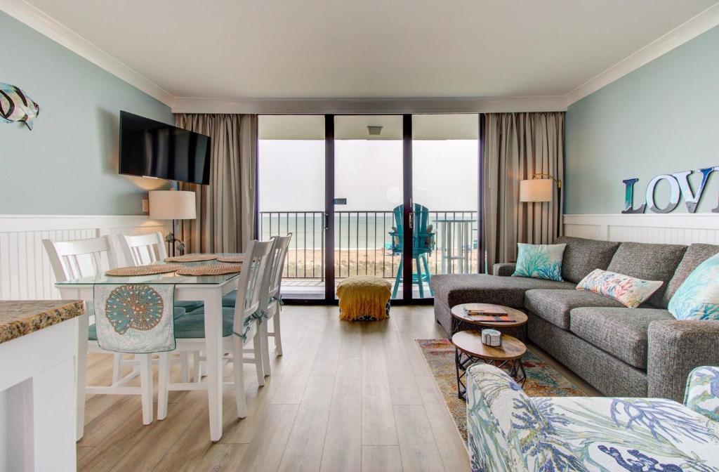 een woonkamer met een bank en een tafel bij 0304 Bountiful Bliss by Atlantic Towers in Carolina Beach