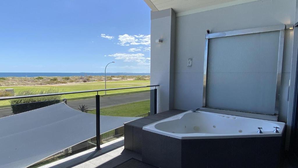 a bath tub in a room with a large window at The Pearl in Jurien Bay