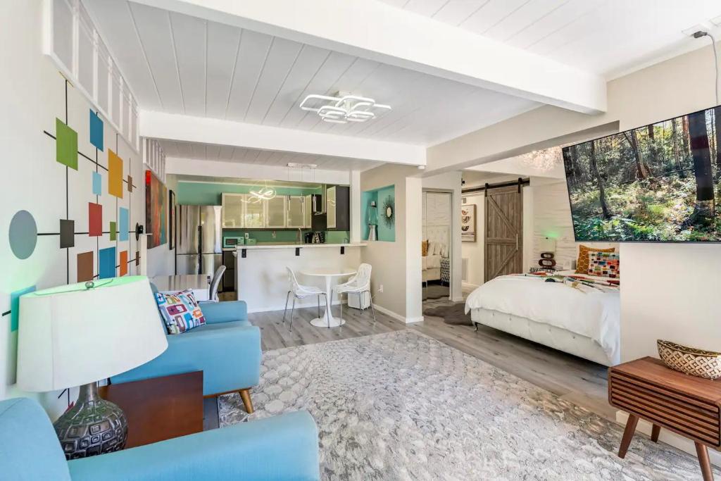 een woonkamer met een blauwe bank en een slaapkamer bij Stylish Retro Luxury Close to SF and Wine Country Regions in San Rafael