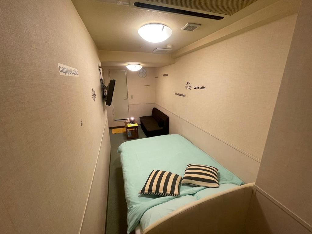 東京にある遊悠館の小さなお部屋で、ベッドに枕2つが備わります。