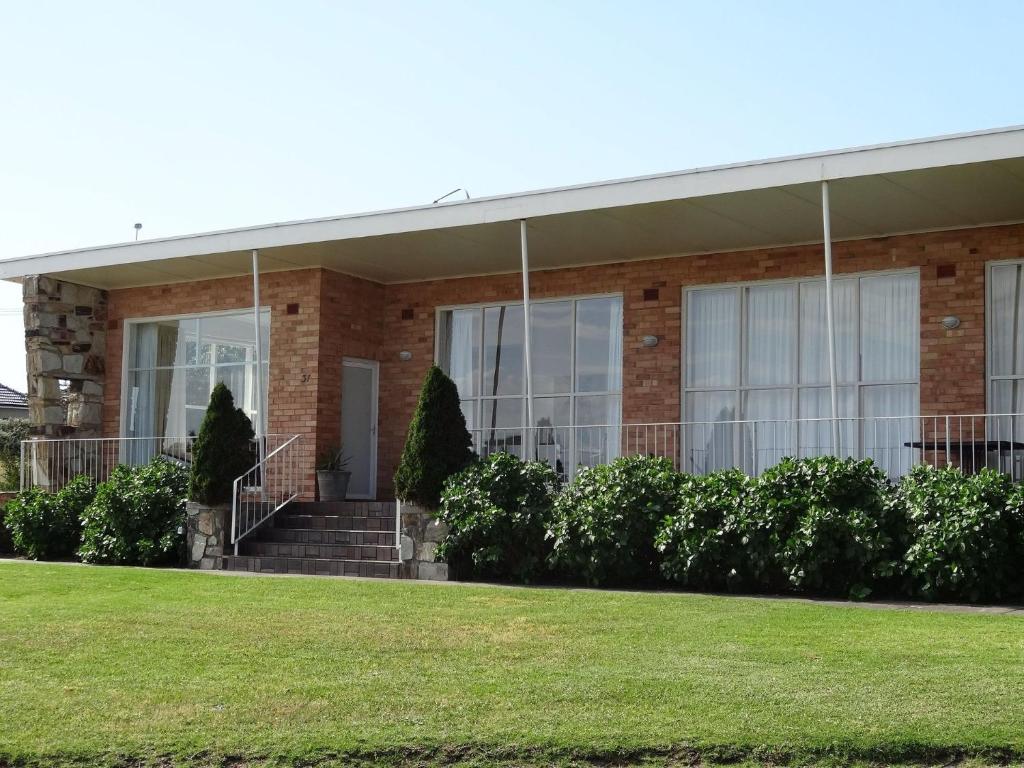 a brick building with stairs and a grass field at Beach Living at Its Best in McCracken