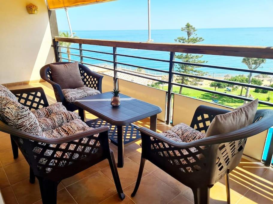 a balcony with chairs and a table and a view of the ocean at 1HAB en Castillo Santa Clara in Torremolinos