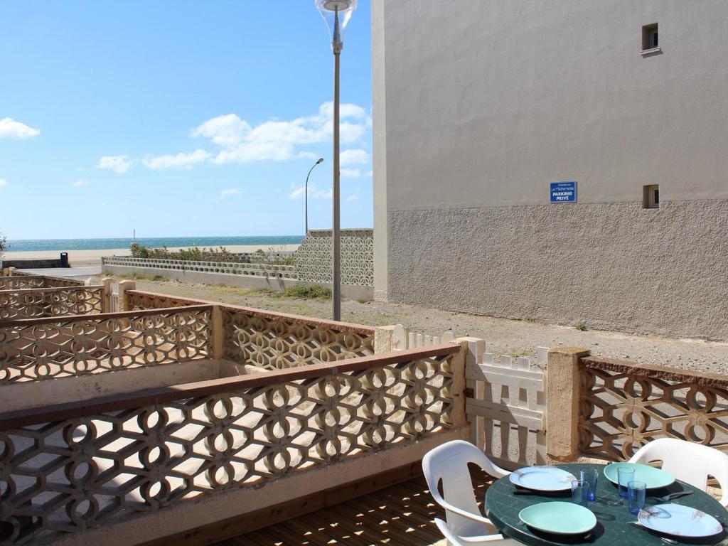 une table et des chaises sur un balcon avec la plage dans l'établissement Appartement T2 en RDC avec terrasse, à 500m du centre de Port-la-Nouvelle, parking et animaux admis - FR-1-229C-81, à Port-la-Nouvelle