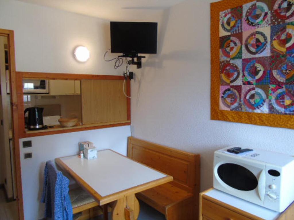 une cuisine avec une petite table et un micro-ondes dans l'établissement Studio à Valfréjus près des pistes, balcon ouest, 3 pers - FR-1-561-39, à Valfréjus