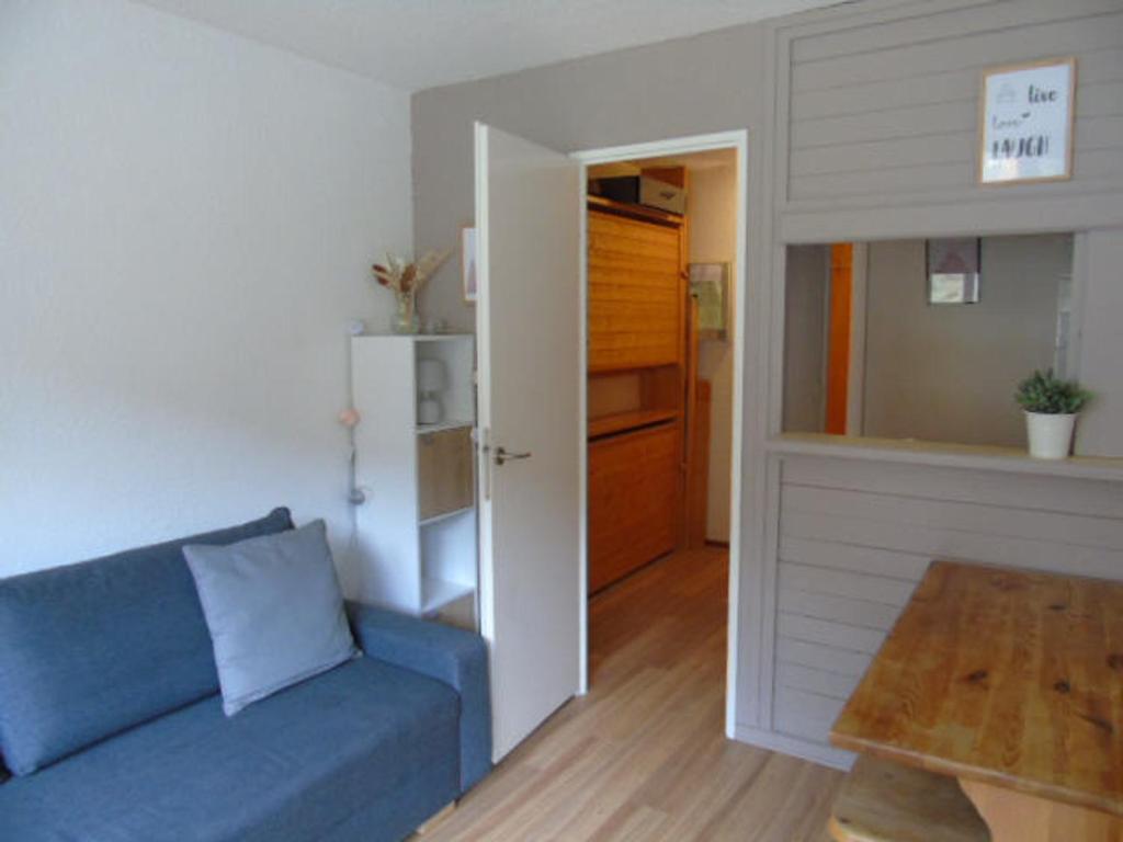 een woonkamer met een blauwe bank en een open deur bij Studio Valfréjus, 1 pièce, 3 personnes - FR-1-561-52 in Valfréjus
