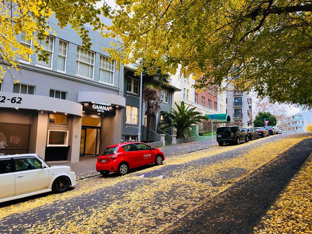 ein rotes Auto, das am Straßenrand geparkt ist in der Unterkunft Gamma Hotel in Auckland