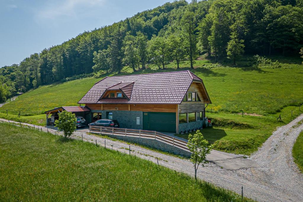 una casa en una colina con un coche aparcado al lado en Ranch Stojnšek House With Sauna - Happy Rentals, en Rogaška Slatina