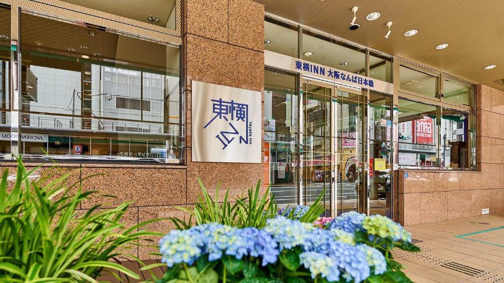a building with flowers in front of a building at Toyoko Inn Osaka Namba Nippombashi in Osaka