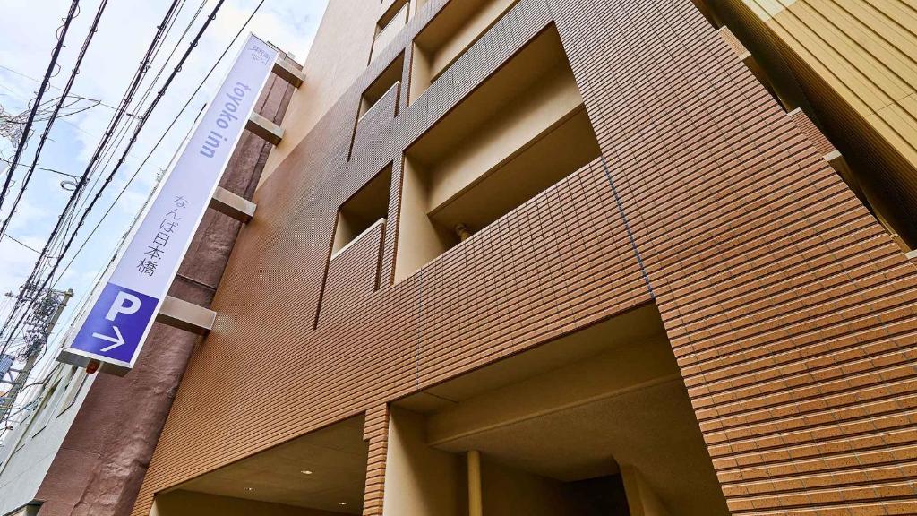 a building with a parking sign on the side of it at Toyoko Inn Osaka Namba Nippombashi in Osaka