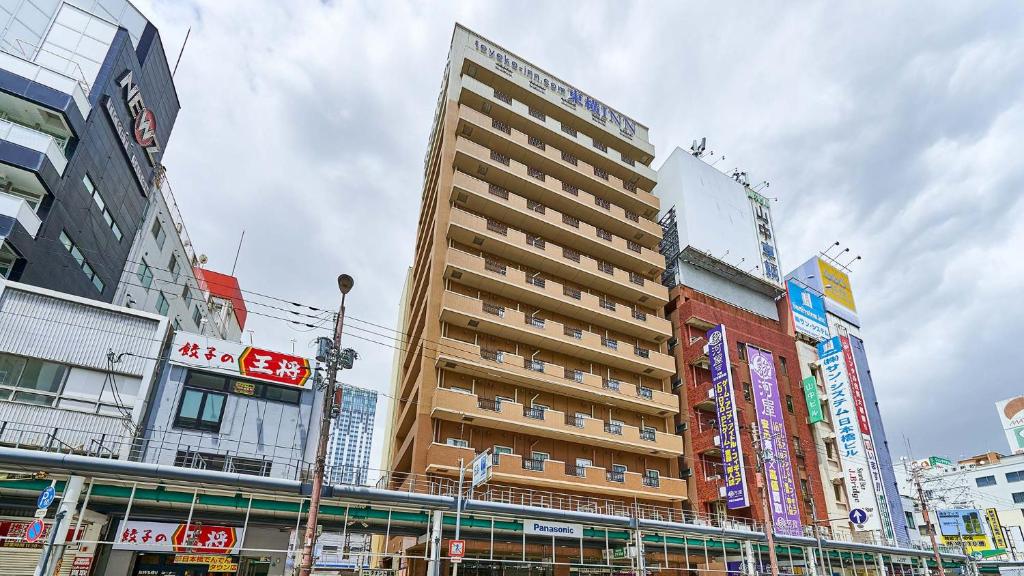 ein hohes Gebäude mitten in einer Stadt in der Unterkunft Toyoko Inn Osaka Namba Nippombashi in Osaka