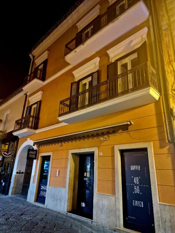 un edificio amarillo con balcón en la parte superior en DOMUS SAN CARLO LUXURY, en Caserta