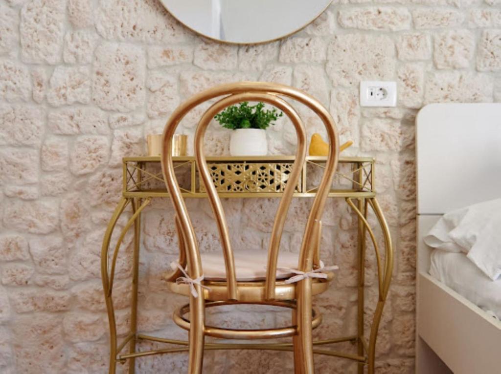 einen Korbstuhl neben einem Tisch mit einem Spiegel in der Unterkunft Guesthouse Ana Trogir Old Town in Trogir