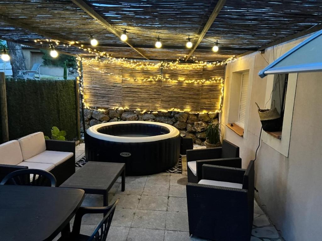 un patio con una grande vasca, tavoli e sedie di Escapade et spa aux gorges du Verdon, spa ouvert juillet et août a La Verdière