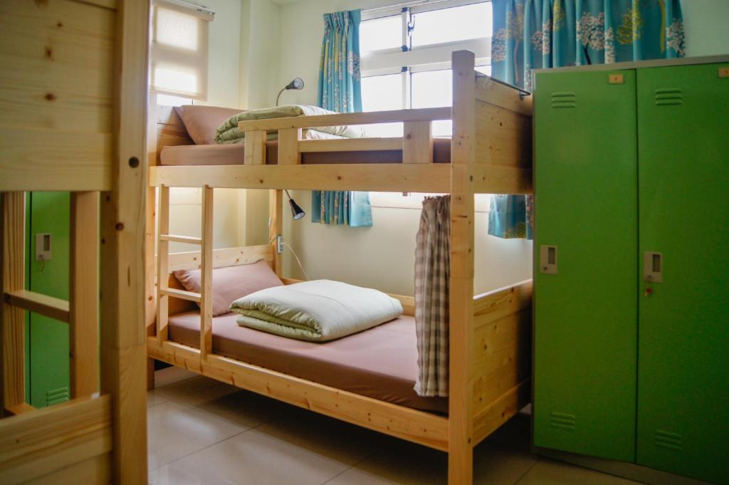 a couple of bunk beds in a room at Happy Tree Hostel in Jinning
