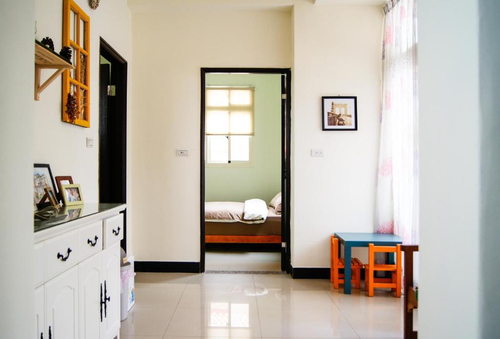 a bedroom with a door leading to a bed at Happy Tree Hostel in Jinning