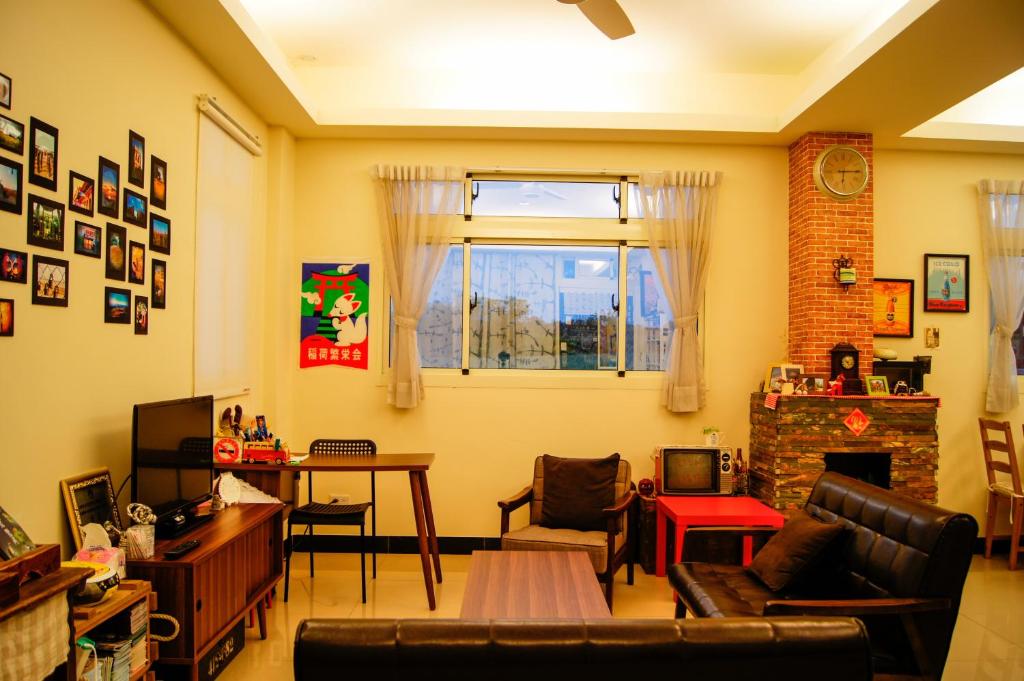 a living room with a couch and a fireplace at Happy Tree Hostel in Jinning