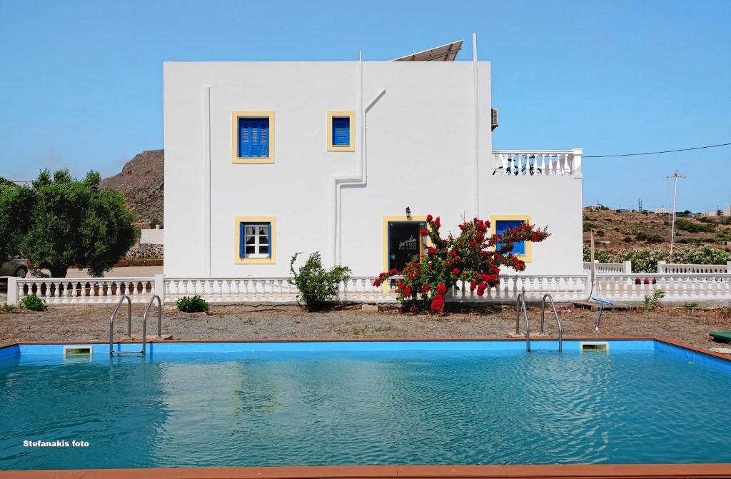 ein Haus und ein Pool vor einem Haus in der Unterkunft Aerikohotel - Apartments in Agía Marína