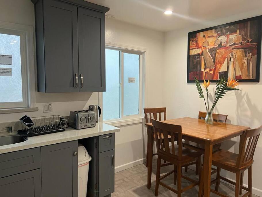 una cucina con tavolo in legno e una sala da pranzo di Affordable Private Rooms with Shared Bath Kitchen near SFO (SA) a Daly City