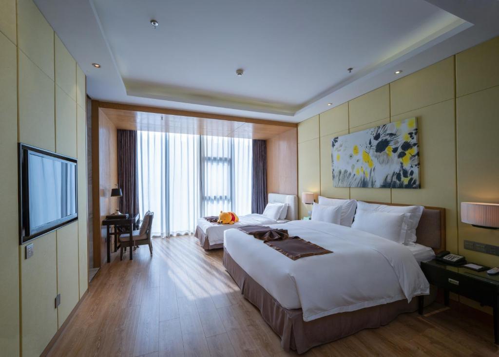 Postel nebo postele na pokoji v ubytování Zhuhai Palm Spring Hotel