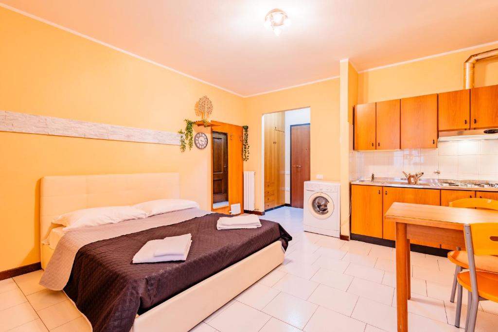 1 Schlafzimmer mit einem großen Bett und einer Küche in der Unterkunft La Santa Maria in Cuneo