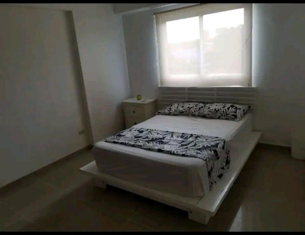 ein kleines Schlafzimmer mit einem Bett und einem Fenster in der Unterkunft Apartamento a 5 minutos Zona Colonial in Santo Domingo