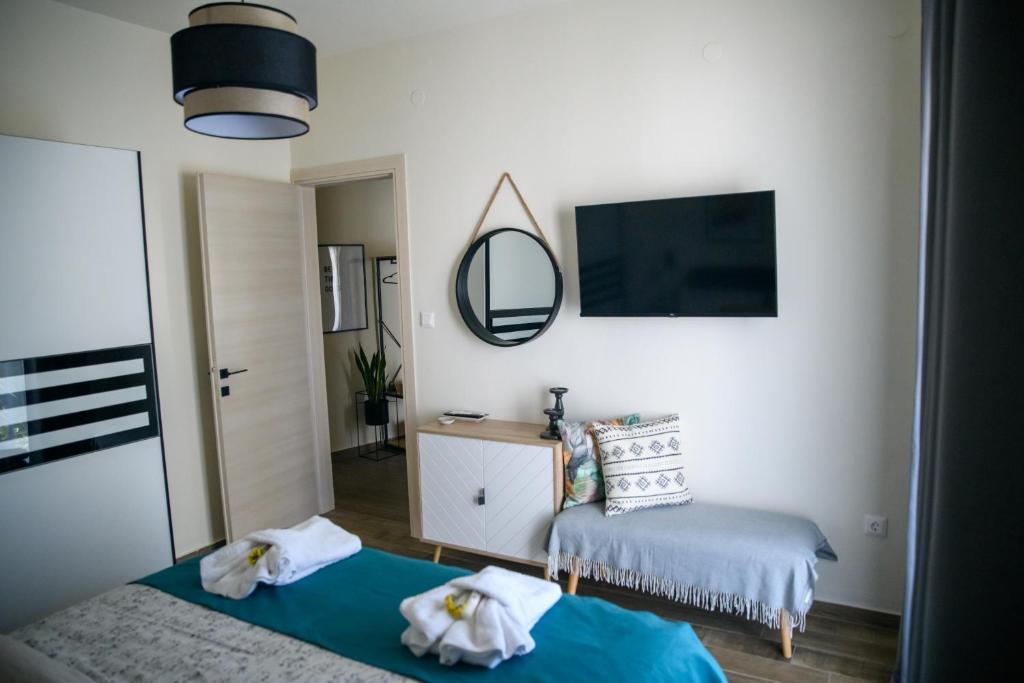 una camera con letto, specchio e sedia di ElMar Homeliving a Volos
