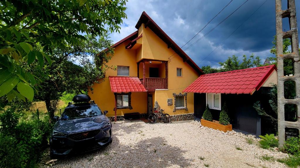 a yellow house with a car parked in front of it at Casablanca in Podu Dîmboviţei