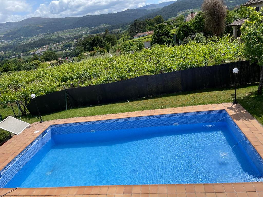 una piscina azul con vistas a una colina en Casa con vistas a Portugal, en Arbo