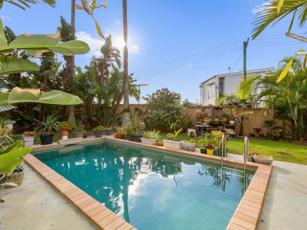 una piscina en un patio con plantas en Blue Horizons Kingscliff with Pool, en Kingscliff