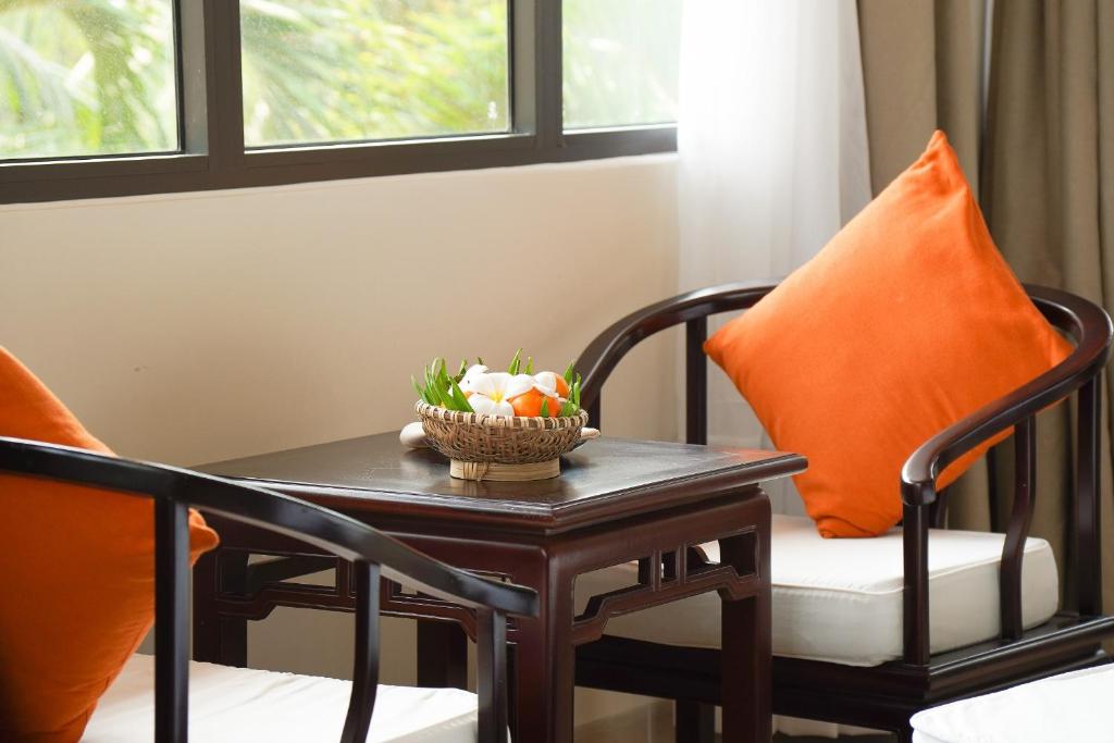 a table and chairs with a bowl of fruit on it at Pax Ana Doc Let Resort & Spa in Ninh Hòa
