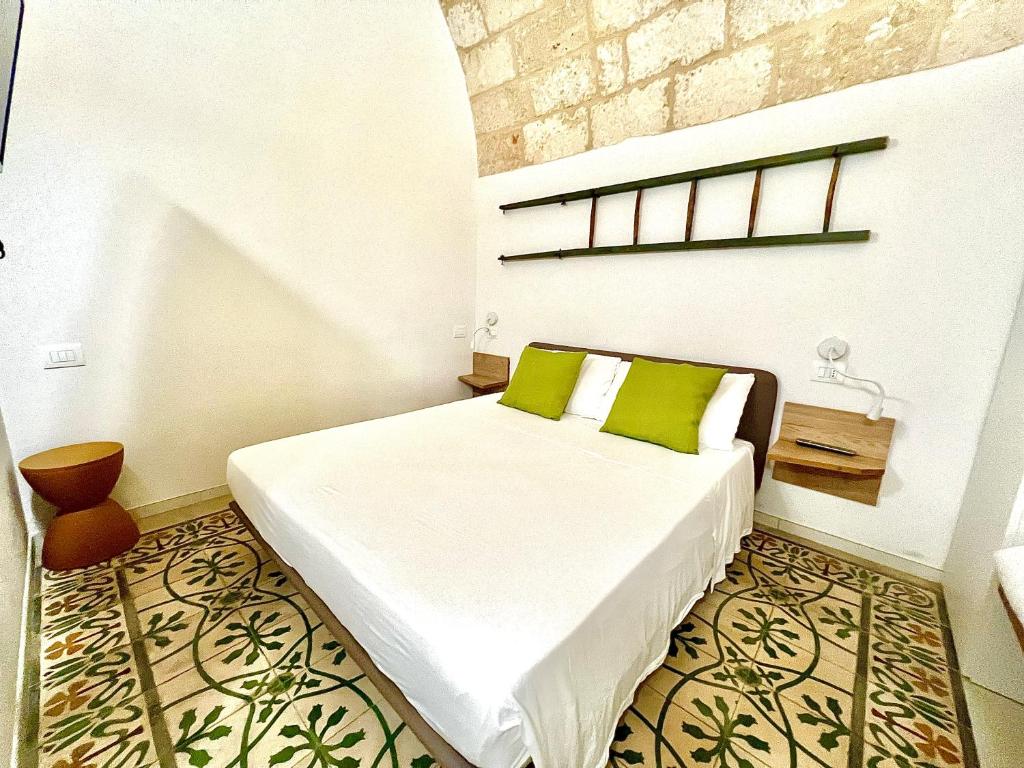 een slaapkamer met een bed met groene kussens erop bij B&B Suite Amare Polignano in Polignano a Mare