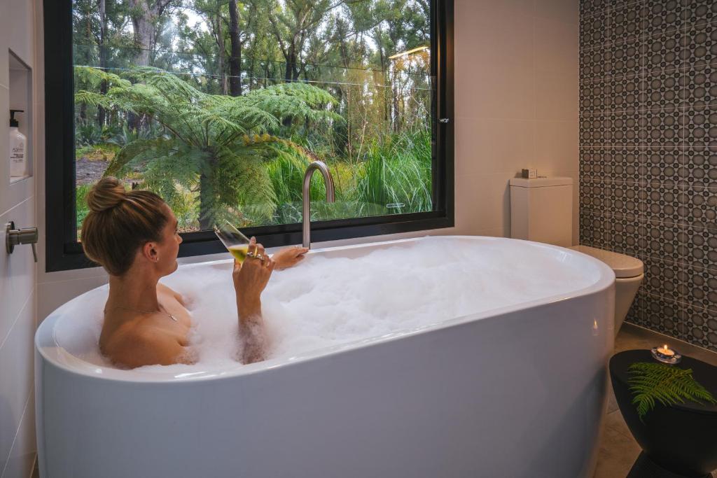 a child playing in a bath tub with a window at The Bower At Broulee in Broulee