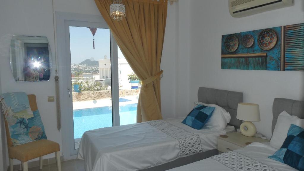 1 Schlafzimmer mit 2 Betten und Poolblick in der Unterkunft Villa Priene - Gumusluk Private Pool in Gümüşlük