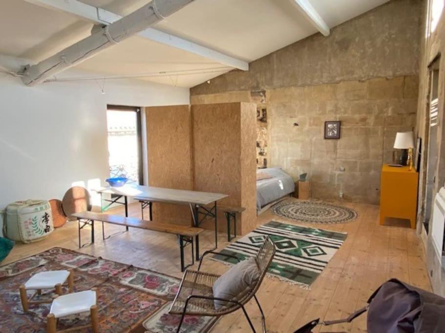 un salon avec une table et des chaises et un lit dans l'établissement Loft sur les toits d'arles, à Arles