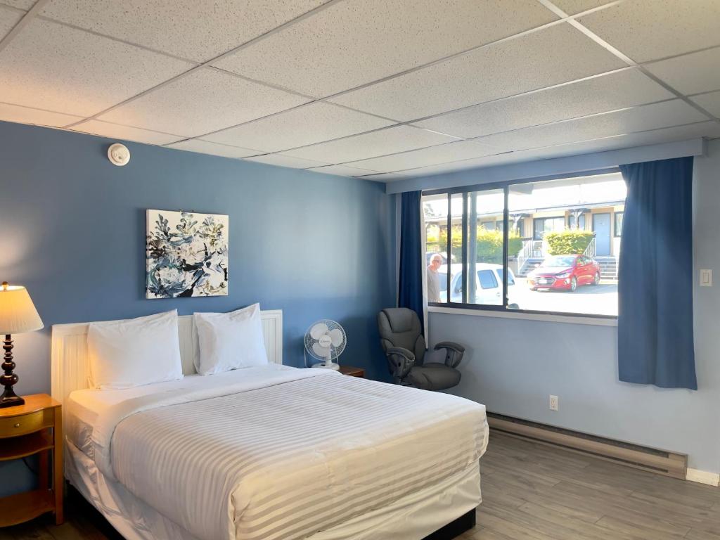 ein Schlafzimmer mit einem großen Bett und einem Fenster in der Unterkunft Departure Bay Motel in Nanaimo