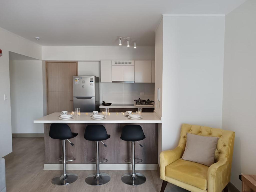 a kitchen with a counter and a yellow chair at lovely apartament with hydromassage in Lima