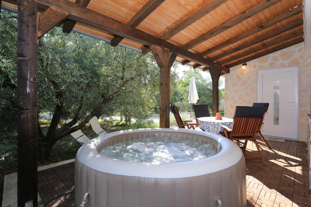 a hot tub on a patio with a pergola at HACIENDA MIA extra in Zadar