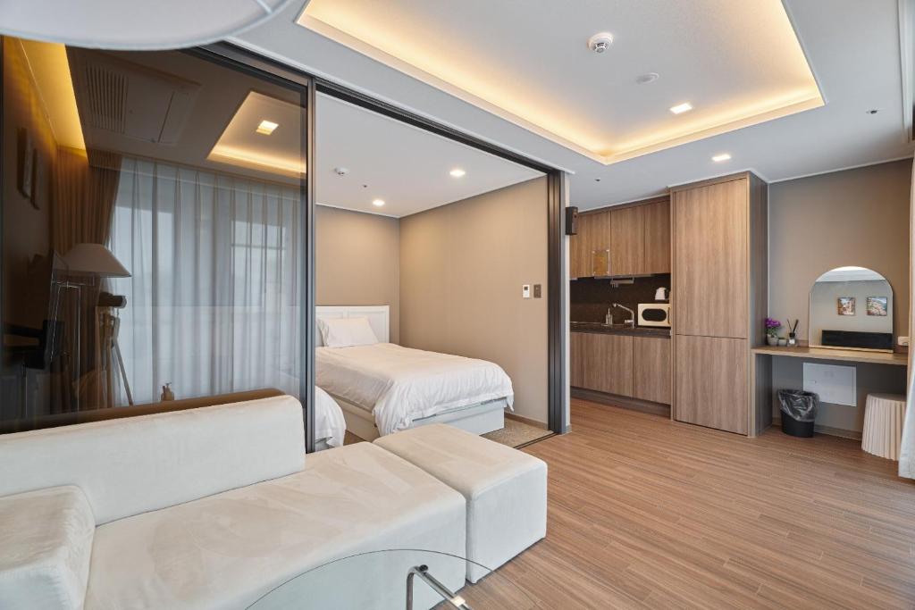 een hotelkamer met een bed en een woonkamer bij Family Hotel & Arbol in Busan