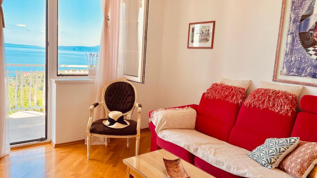 a living room with a red couch and a window at Seaview Apartment Bosnjak Opatija in Ičići