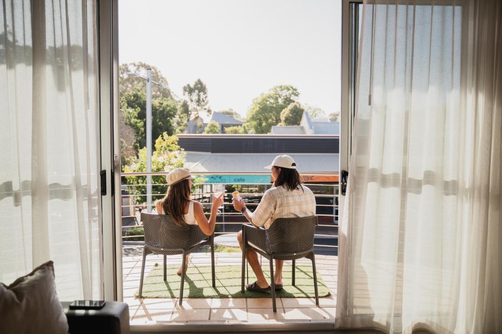 two women sitting in chairs on a balcony at 107 Apartments Margaret River in Margaret River Town