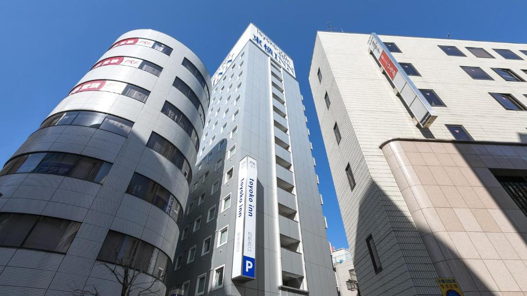 três edifícios altos estão um ao lado do outro em Toyoko Inn Kashiwa eki Nishi guchi em Kashiwa