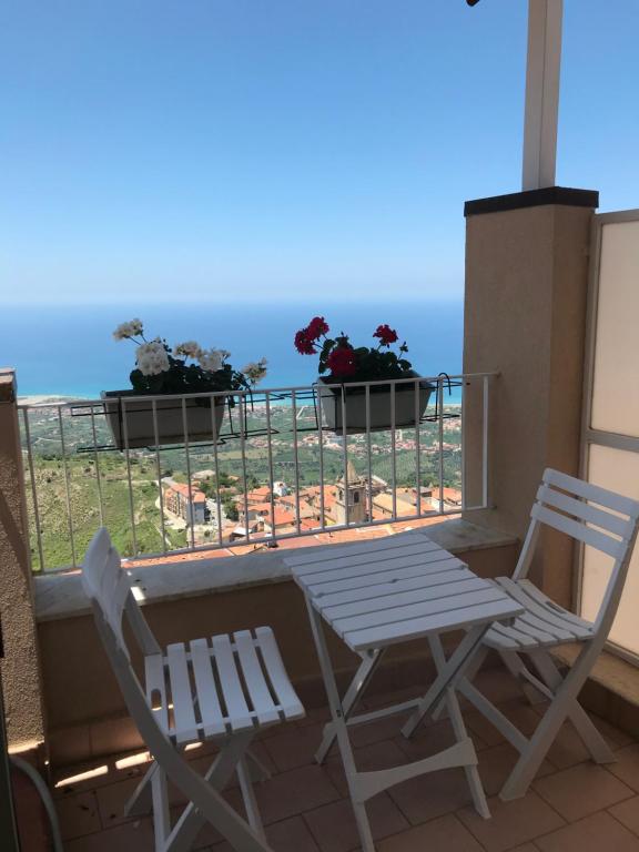 2 stoelen en een tafel op een balkon met bloemen bij La Tela Di Penelope in San Marco dʼAlunzio